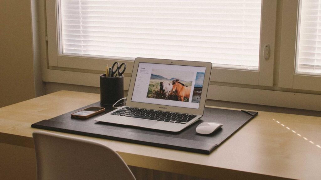Hardware wallet beside a laptop displaying transaction details